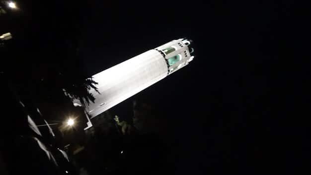 A close-up shot of a SpaceX Falcon 9 rocket launching into space, showcasing the technology behind reusable rockets and the decreasing costs of space travel.