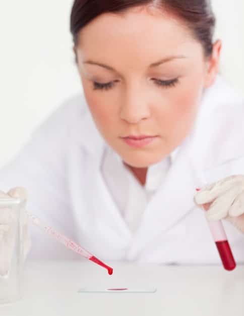 A close-up shot of a scientist in a lab coat using a pipette to transfer a liquid sample into a microplate. The lab environment should be modern and well-lit, with various pieces of advanced equipment visible in the background. Focus on the precision and scientific nature of the work.