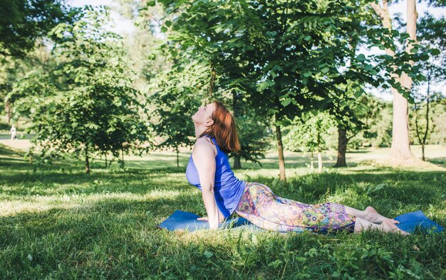 A person practicing yoga in a park, surrounded by trees and greenery, embodying mindful movement and connection with nature.