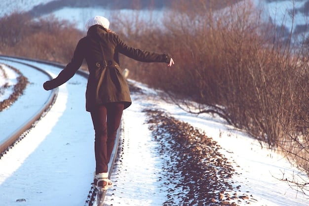 A person bundled up in warm clothing, walking outdoors in a snowy landscape with clear blue skies. The sun is shining brightly, casting long shadows on the snow. The image captures the serenity and mood-boosting effects of spending time in nature.