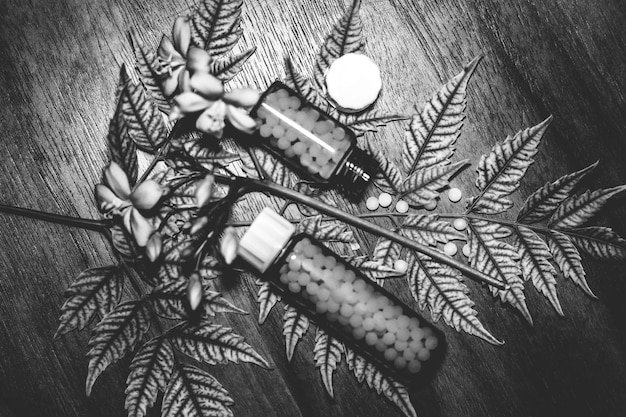 A somber image depicting a pile of prescription bottles scattered on a wooden table, with some pills spilled out. The dark tone evokes themes of addiction, dependency, and the risks associated with prescription opioids.