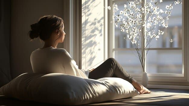 A person sitting comfortably on a cushion, eyes closed, with gentle sunlight streaming in through a window. They are practicing mindfulness meditation at home, emphasizing the accessibility and simplicity of the technique.