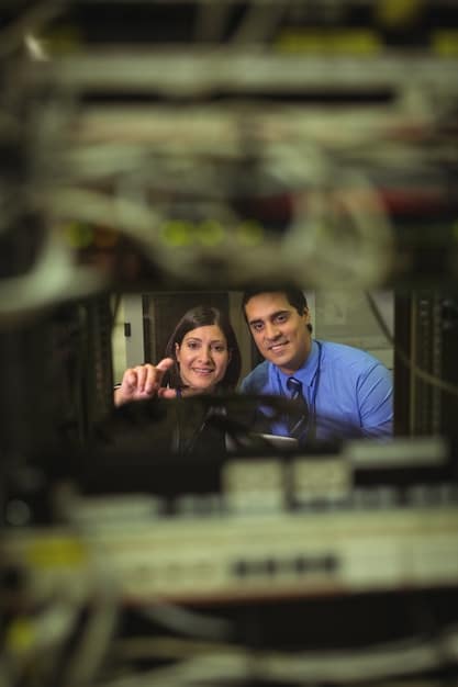 A team of engineers in a brightly lit control room monitoring the performance of automated systems in a US manufacturing plant. The image portrays a collaborative environment with advanced technology.